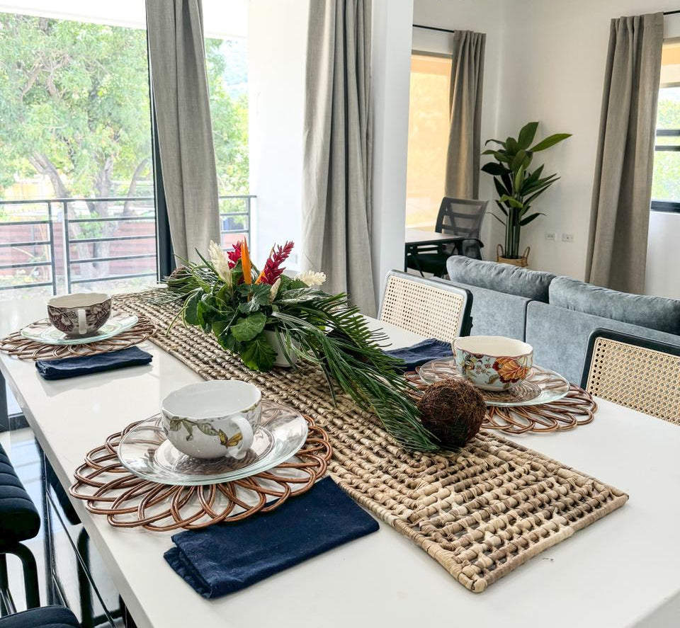 Dining table set with decorative items in a modern living room.